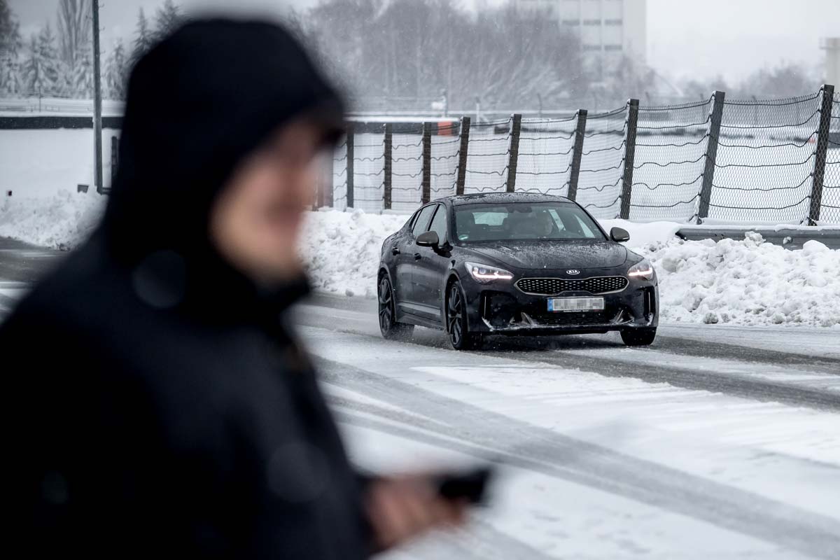 Auto fährt im Schnee, Fahrtrainer im Vordergrund